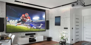 Modern living room with a projector mounted on the ceiling, with the projector displaying a football match on the wall.